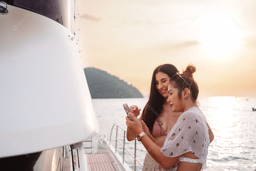 Duas belas amigas no iate de luxo. Se divertindo juntos e aproveitando o sol