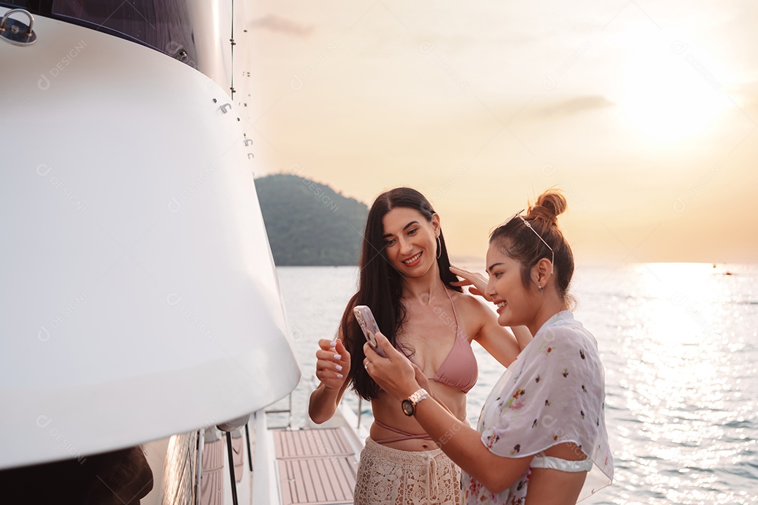 Duas belas amigas no iate de luxo. Se divertindo juntos e aproveitando o sol