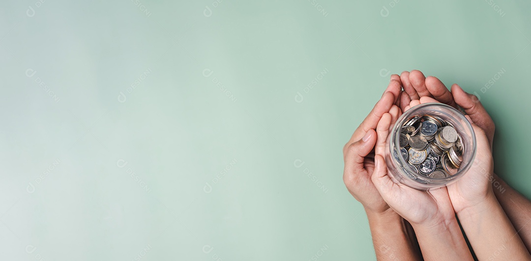 Mãos de adulto e criança segurando pote de dinheiro, doação, poupança