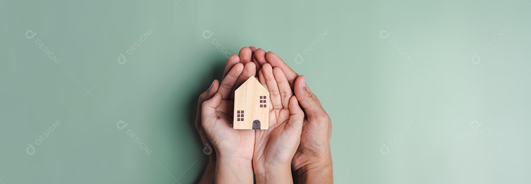 mãos segurando casa de madeira, casa de família