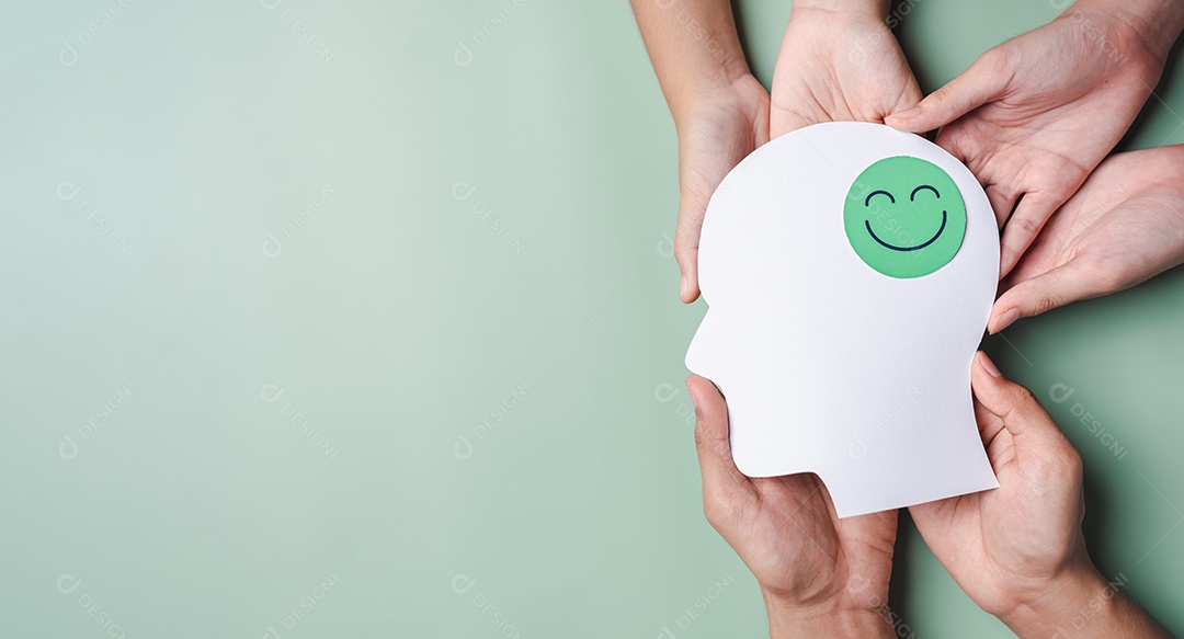 Mãos segurando um rosto sorridente em corte de papel cerebral