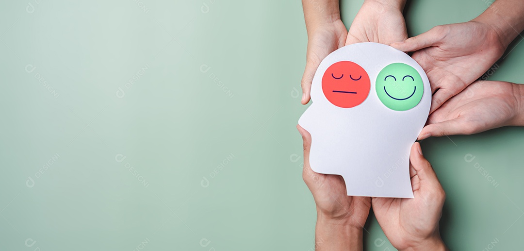 Mãos segurando rosto triste e rosto sorridente feliz em papel cerebral cortado