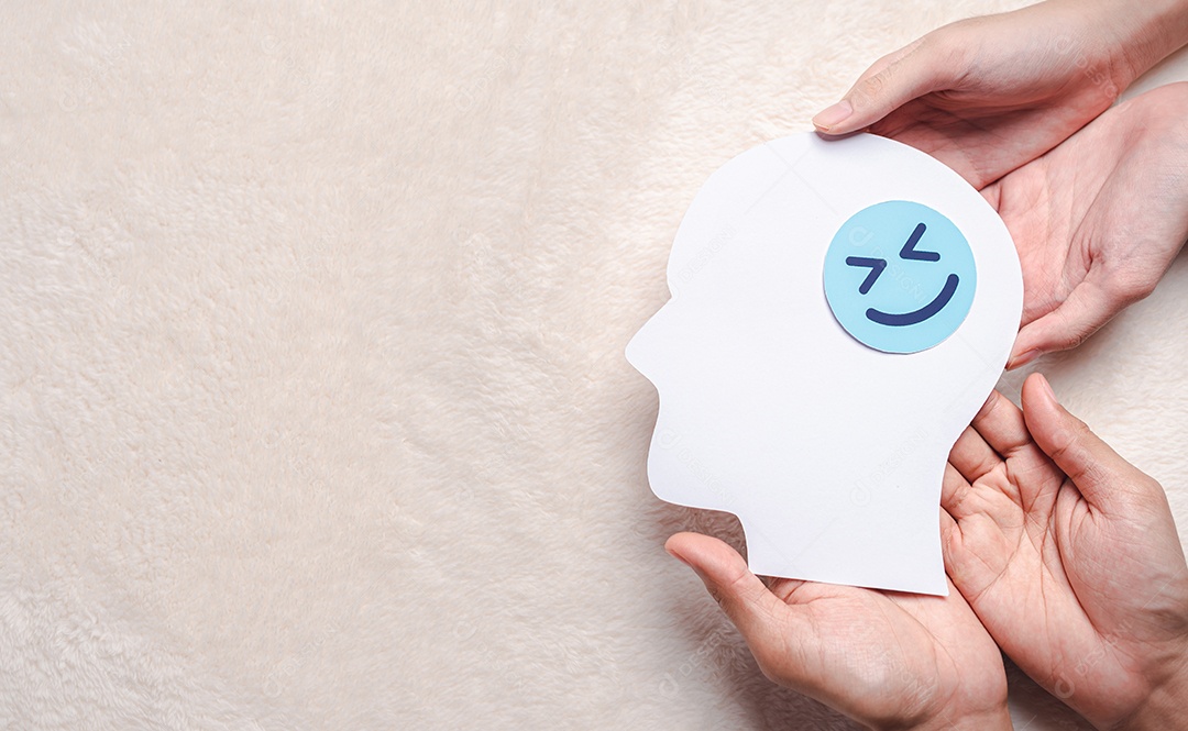 Mãos segurando um rosto sorridente em corte de papel cerebral, emoção sorridente feliz