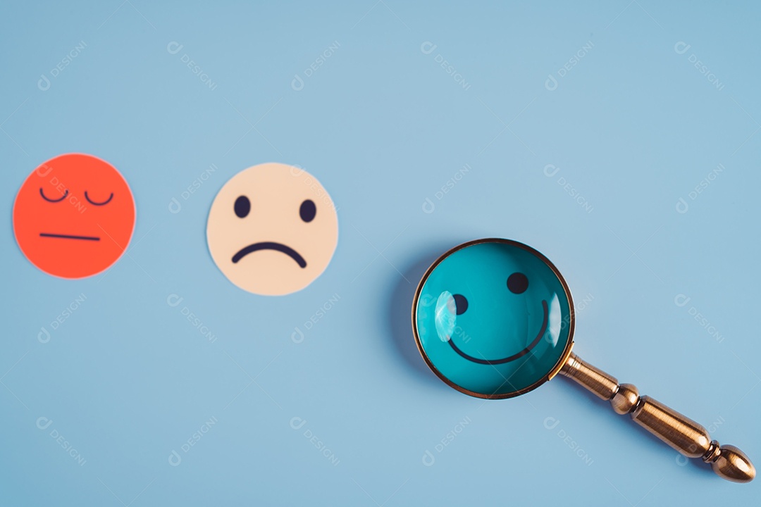 Mão segurando lupa foco selecionado corte de papel de rosto sorridente feliz que está entre várias emoções