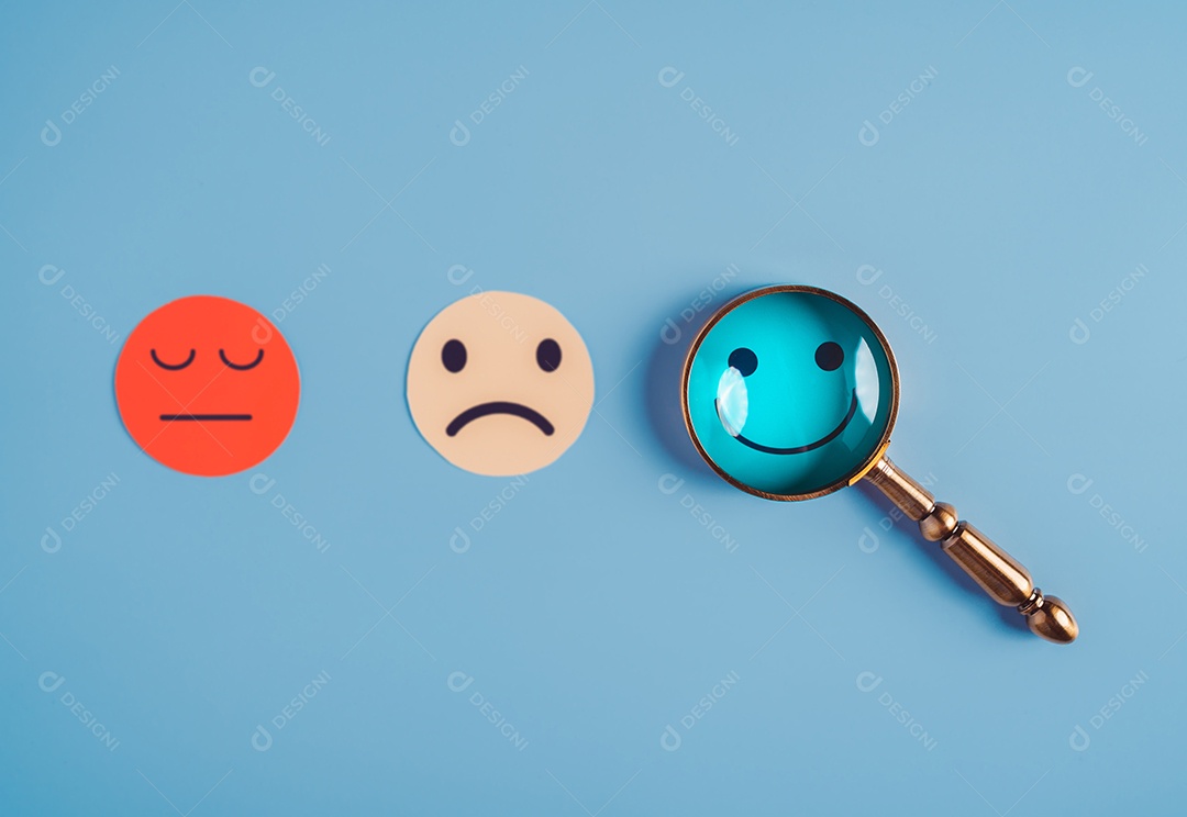 Mão segurando lupa foco selecionado corte de papel de rosto sorridente feliz que está entre várias emoções