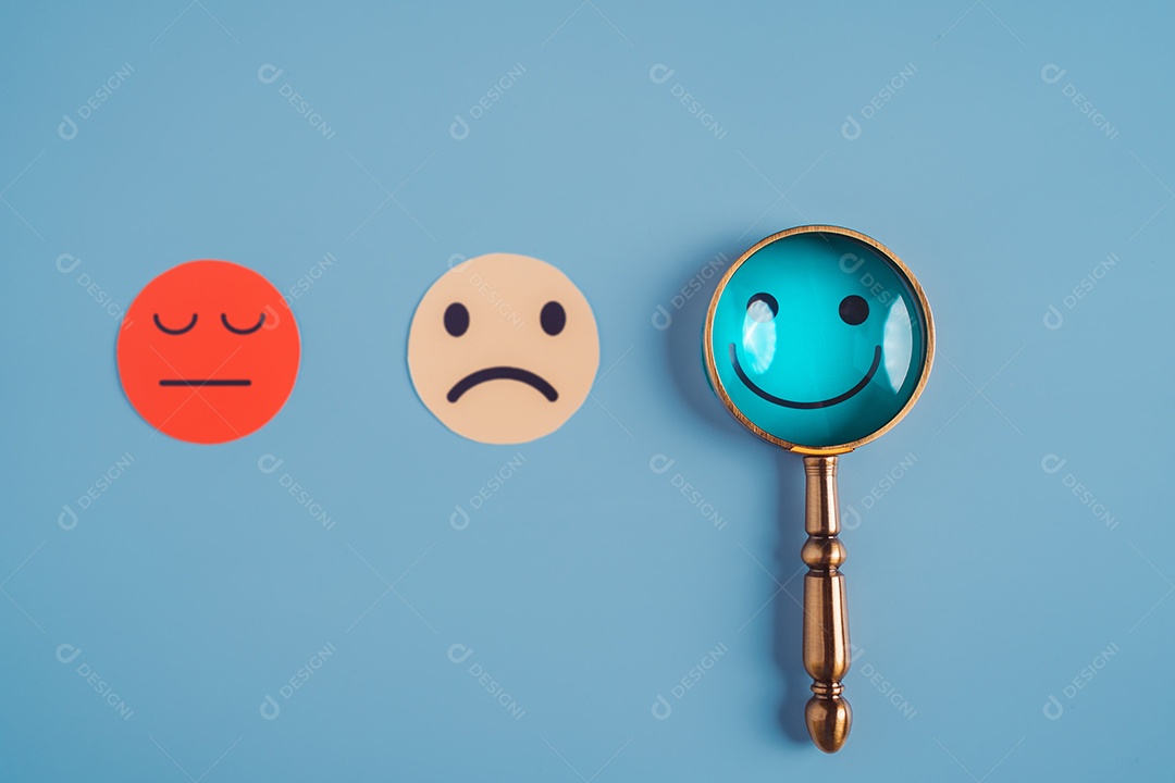 Mão segurando lupa foco selecionado corte de papel de rosto sorridente feliz que está entre várias emoções