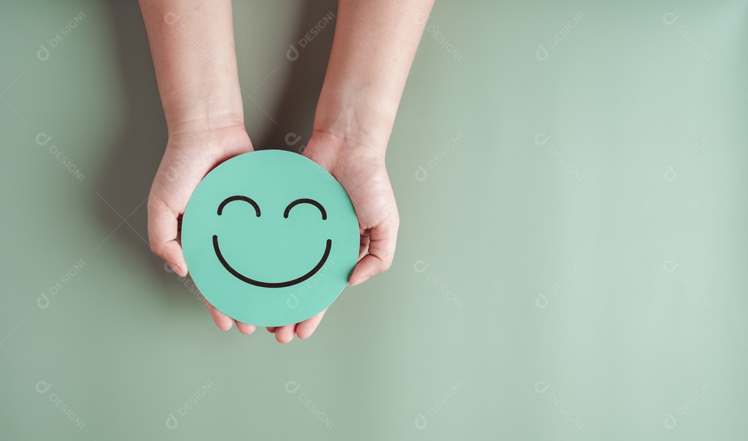 Mãos segurando um sorriso feliz verde, boa classificação de feedback, avaliação positiva do cliente