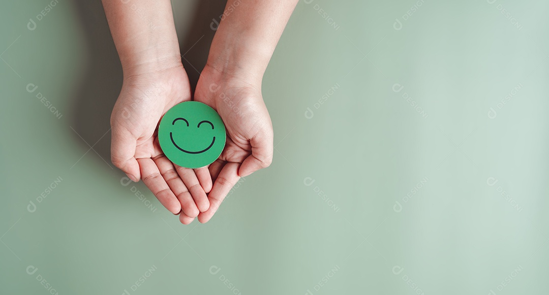 Mãos segurando um sorriso feliz verde, boa classificação de feedback, avaliação positiva do cliente