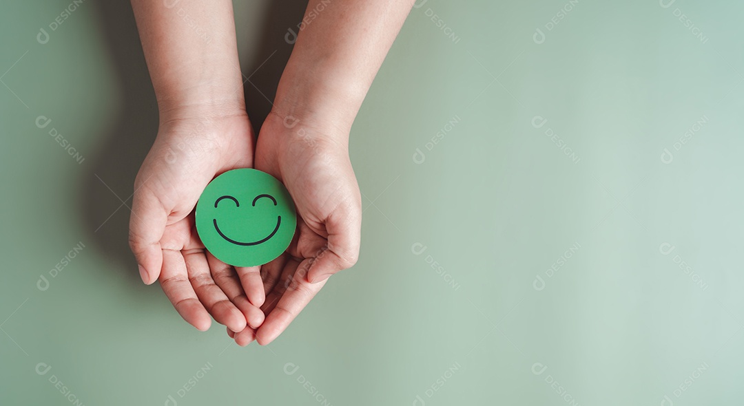 Mãos segurando um sorriso feliz verde, boa classificação de feedback, avaliação positiva do cliente