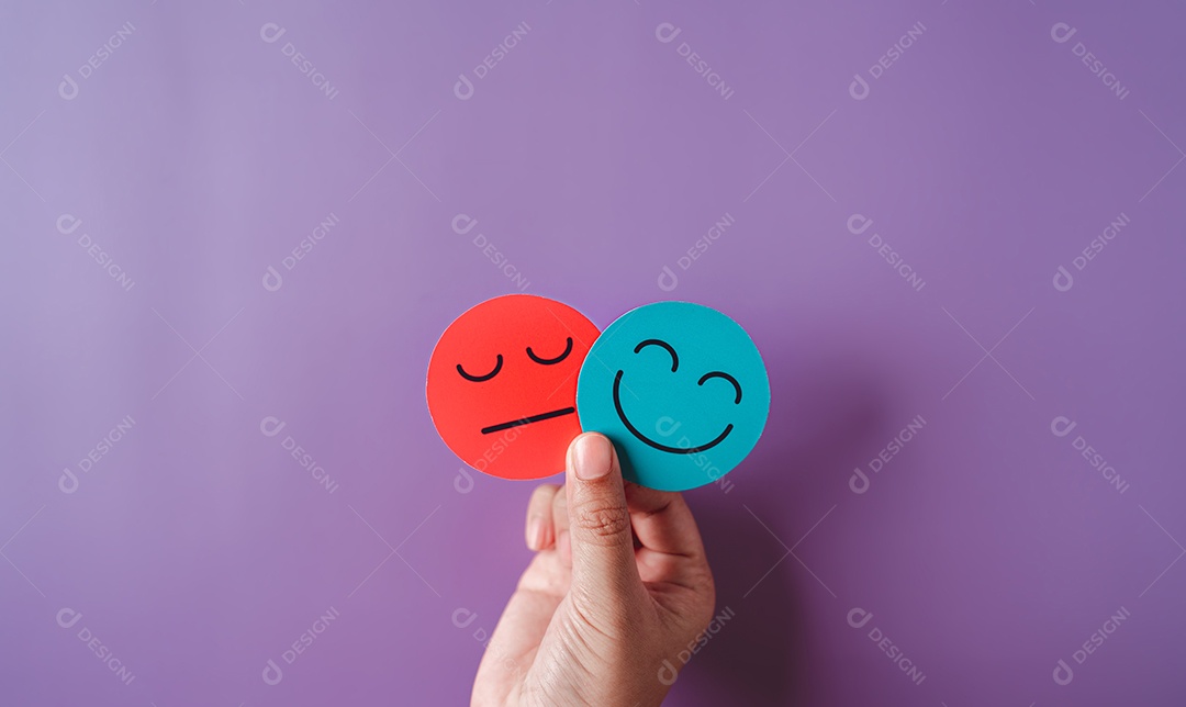 Mãos segurando um rosto triste escondido ou atrás de um rosto sorridente feliz, bipolar e depressão, conceito de saúde mental