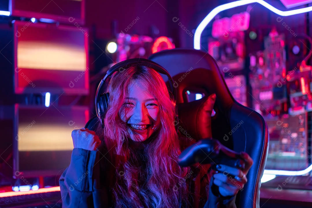 Jogadores felizes jogando videogame online com telefone celular inteligente com luzes de neon