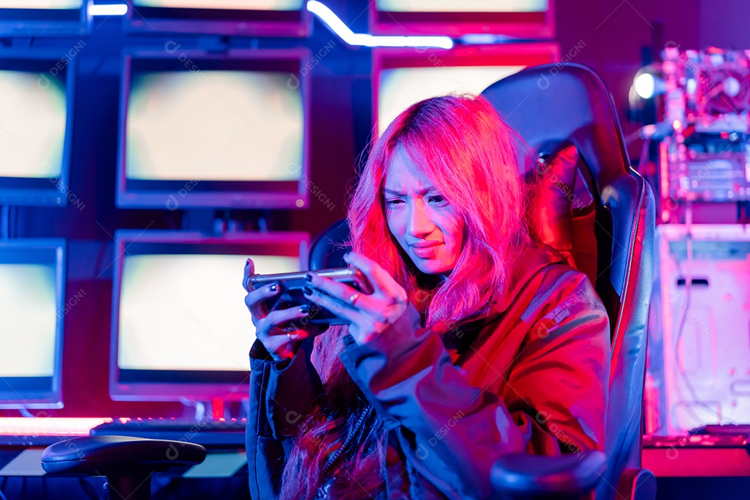 Jogadores felizes jogando videogame online com telefone celular inteligente com luzes de neon