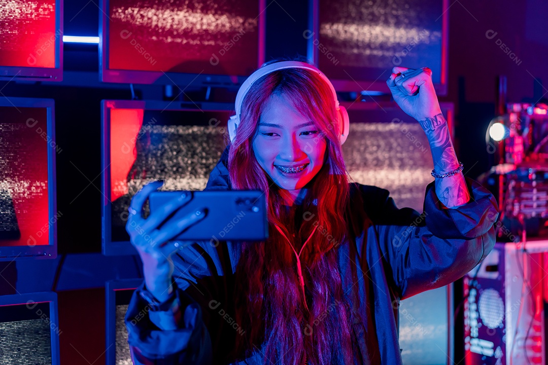 Jogadores felizes jogando videogame online com telefone celular inteligente com luzes de neon