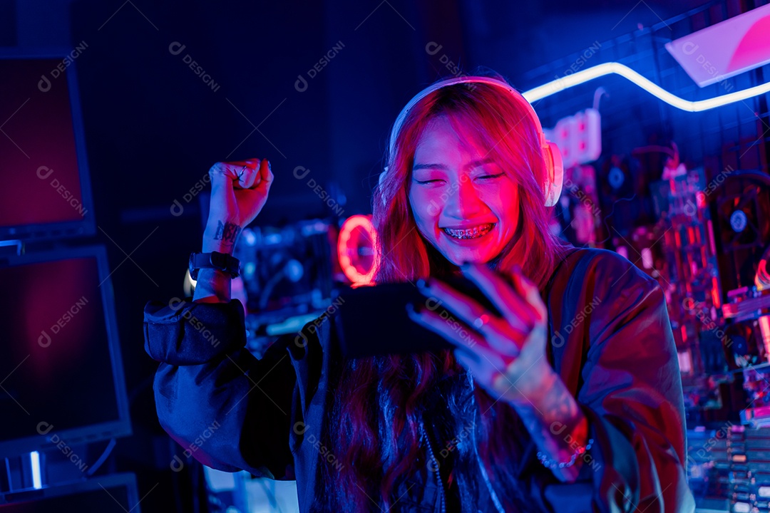 Jogadores felizes jogando videogame online com telefone celular inteligente com luzes de neon