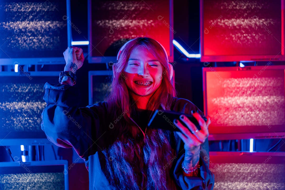 Jogadores felizes jogando videogame online com telefone celular inteligente com luzes de neon