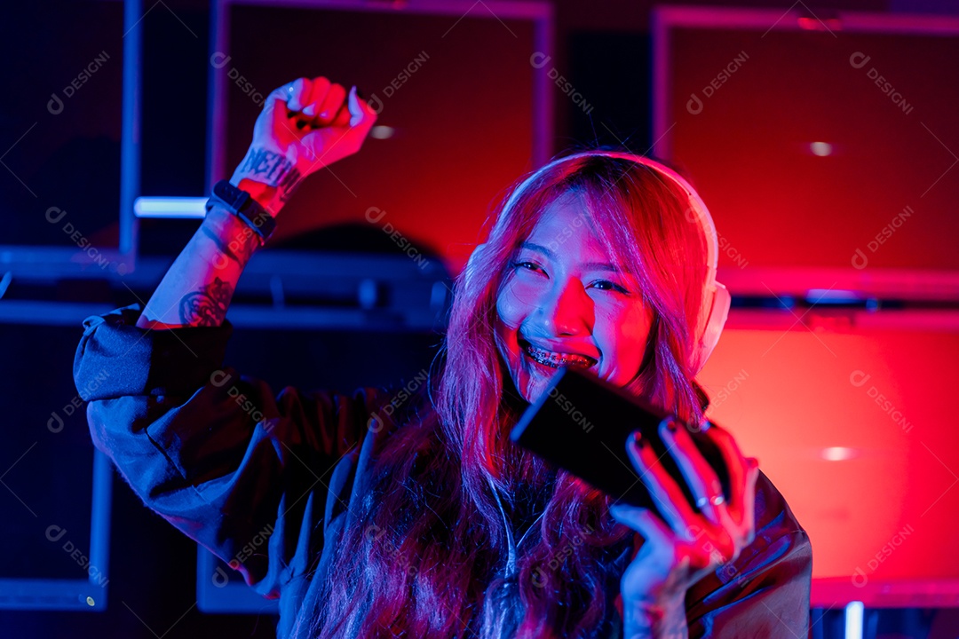 Jogadores felizes jogando videogame online com telefone celular inteligente com luzes de neon