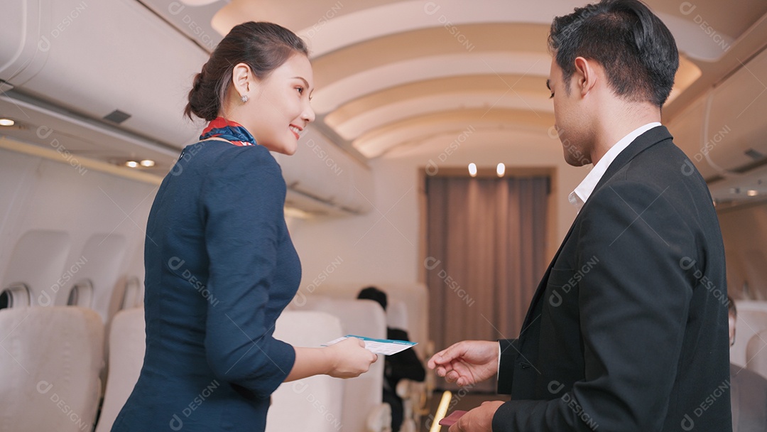 A aeromoça do avião verifica os bilhetes de viagem do empresário antes de decolar no avião