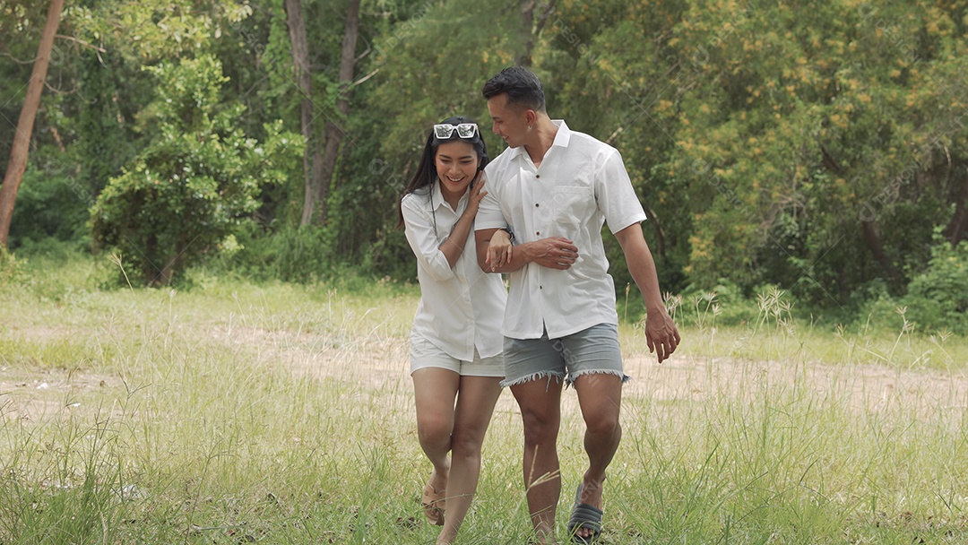 Casal asiático jovem e mulher caminhando viajam na floresta feliz romântico ao ar livre