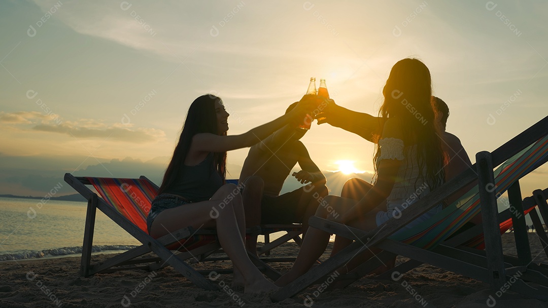 Grupo de amigos na praia bebendo e se divertindo em viagem