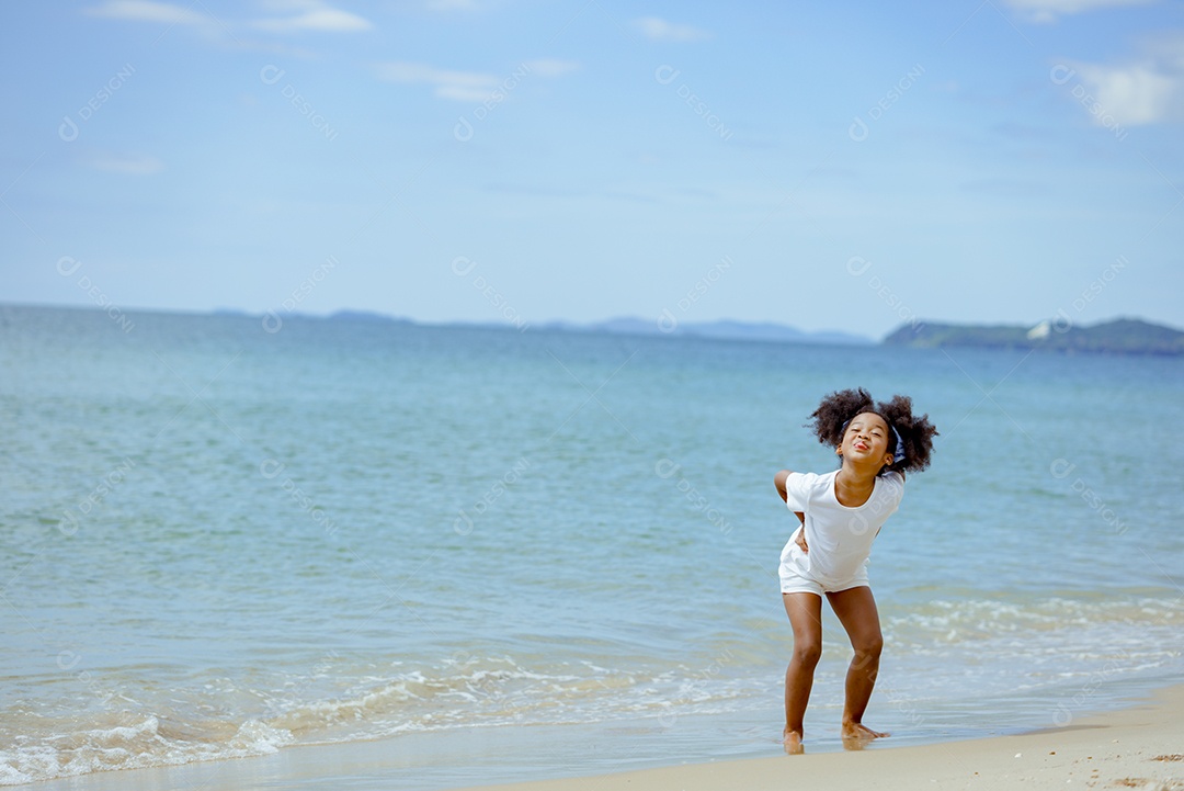 Menina andando sobre areia da praia em férias de verão