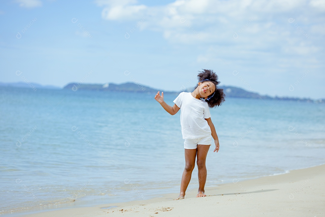 Menina andando sobre areia da praia em férias de verão
