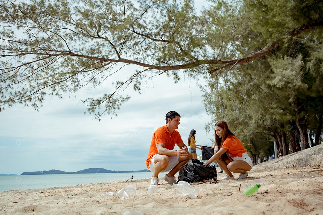 Voluntários coletando lixo na areia da praia