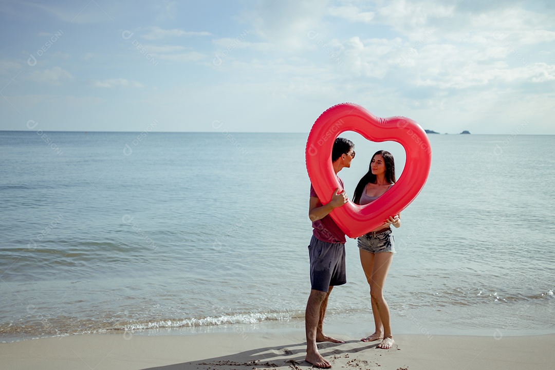 Casal jovem e mulher olhando o mar na praia viajam felizes
