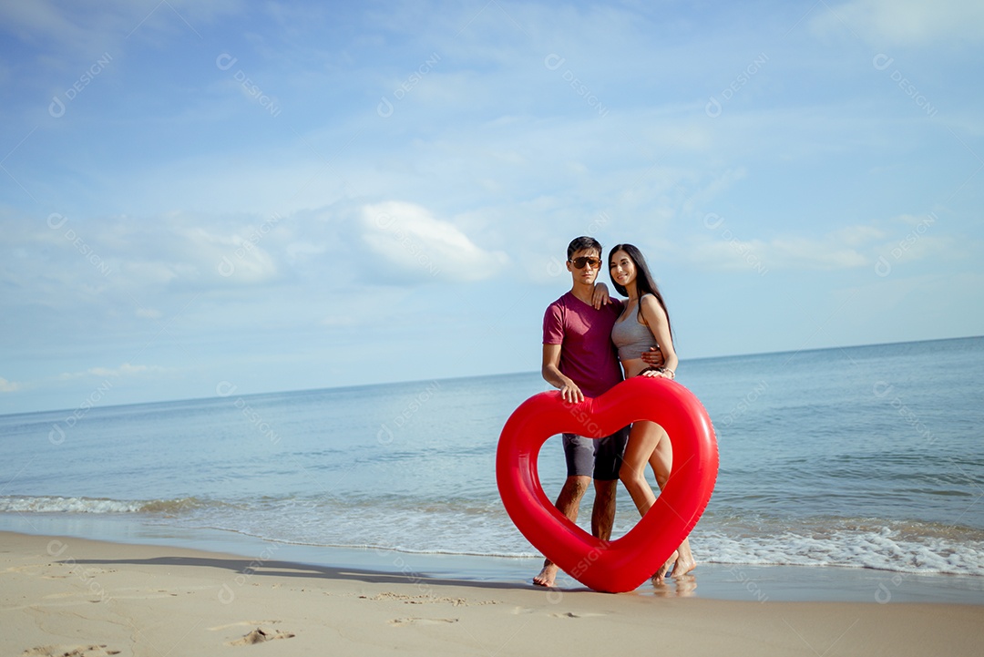 Casal jovem e mulher olhando o mar na praia viajam felizes
