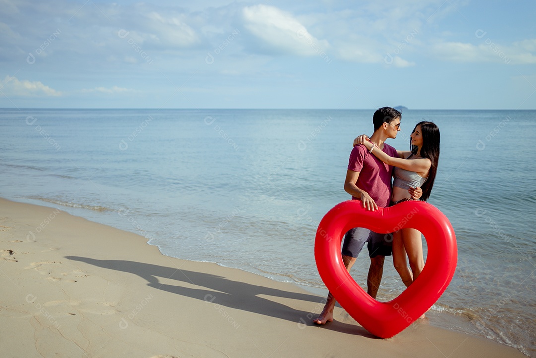 Casal jovem e mulher olhando o mar na praia viajam felizes