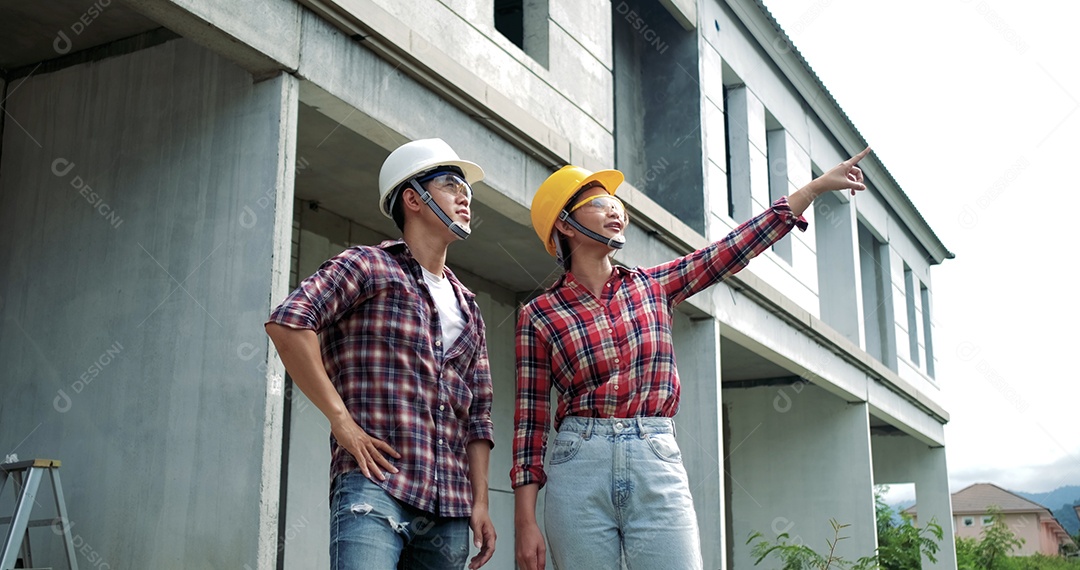 Equipamento de segurança de engenheiro industrial asiático jovem masculino e feminino no canteiro de obras.