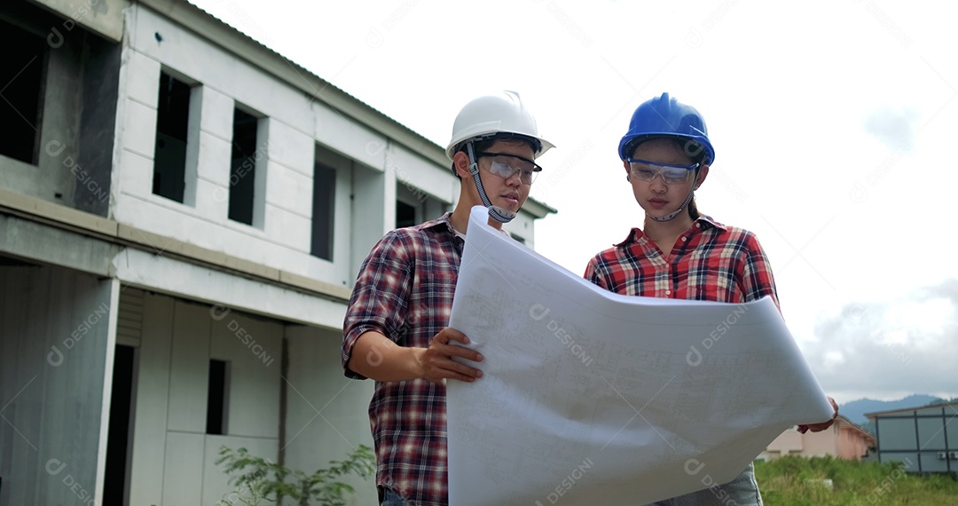 Equipamento de segurança de engenheiro industrial asiático jovem masculino e feminino no canteiro de obras.