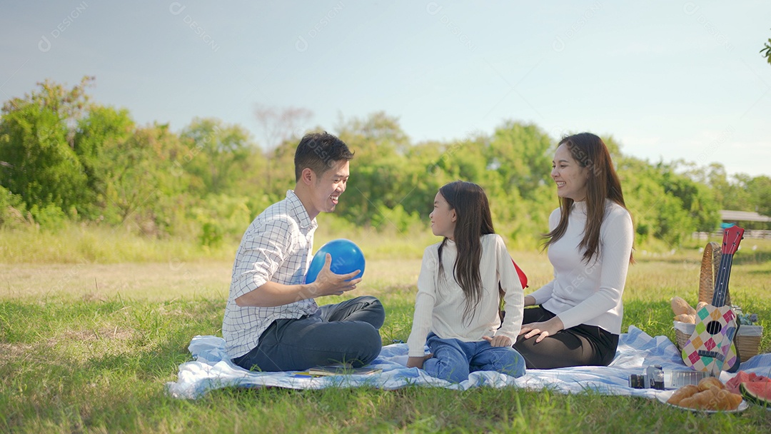 Mãe asiática e família feliz jogando balão e se divertimos
