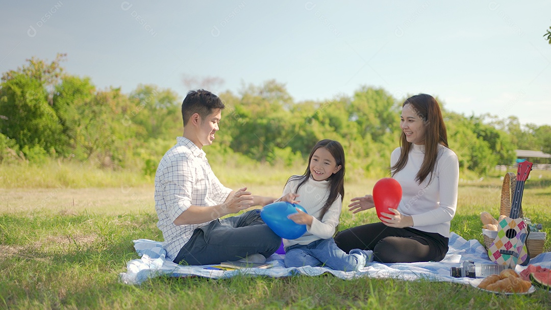 Mãe asiática e família feliz jogando balão e se divertimos