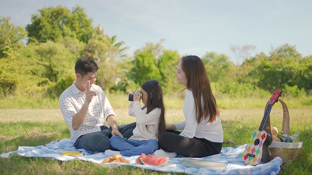 Feliz família asiática e garotinha tirando fotos com a câmera
