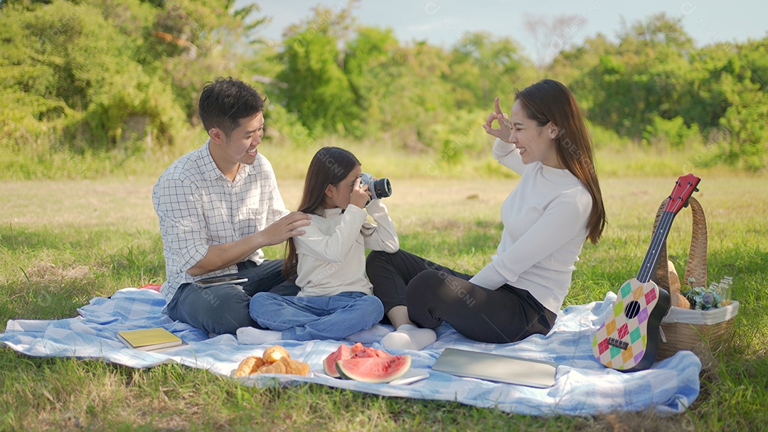 Feliz família asiática e garotinha tirando fotos com a câmera