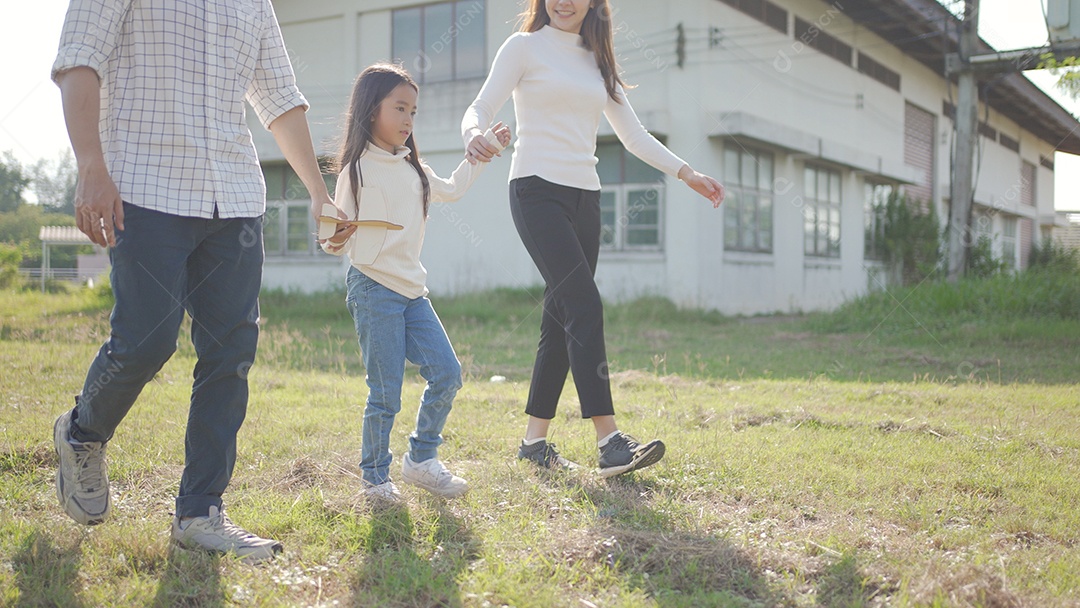 Feliz jovem família asiática caminhando no caminho de mãos dadas com sua filhinha