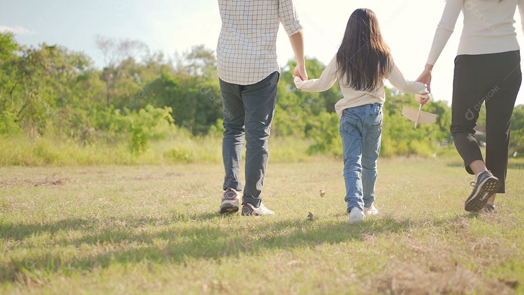 Feliz jovem família asiática caminhando no caminho de mãos dadas com sua filhinha