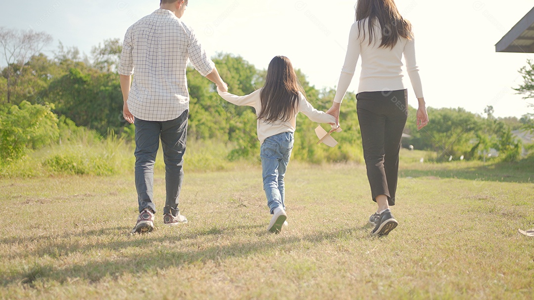 Feliz jovem família asiática caminhando no caminho de mãos dadas com sua filhinha