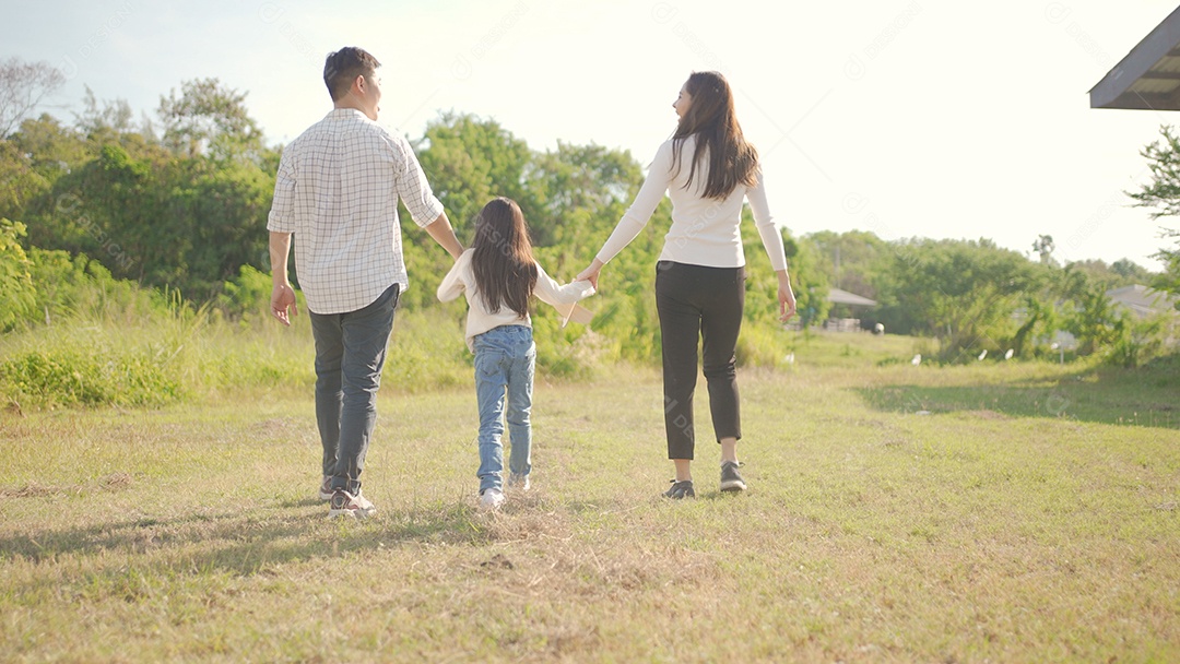 Feliz jovem família asiática caminhando no caminho de mãos dadas com sua filhinha