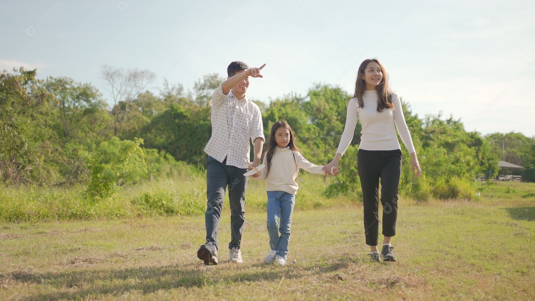 Feliz jovem família asiática caminhando no caminho de mãos dadas com sua filhinha