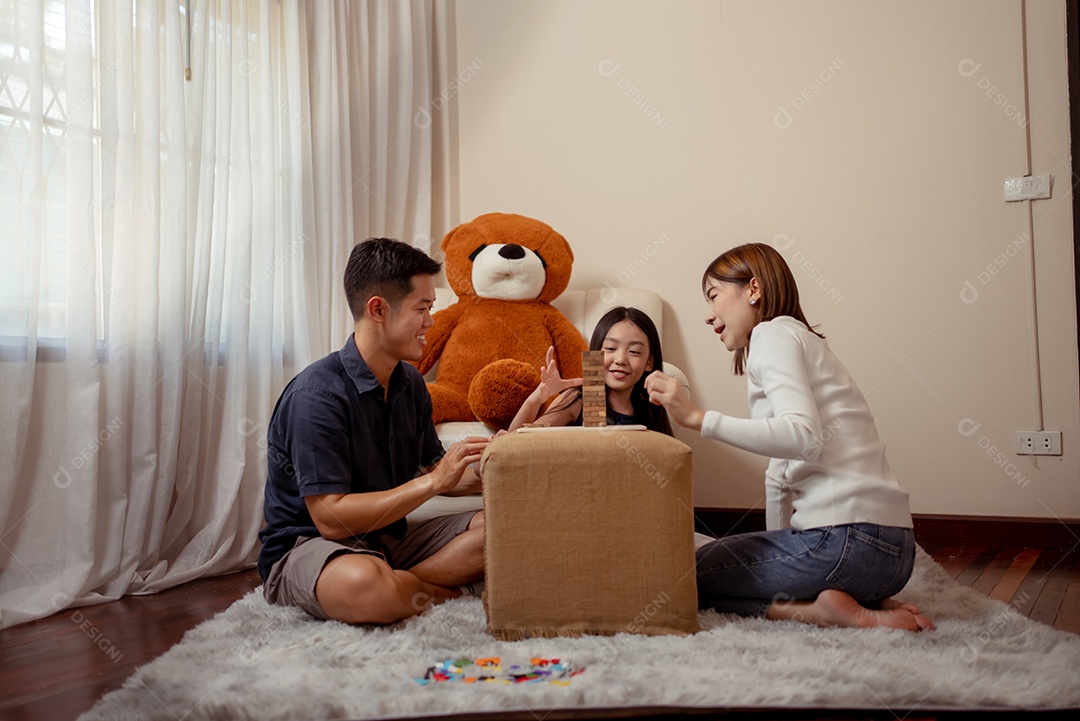 Feliz família asiática se divertindo jogando jogo de blocos em casa