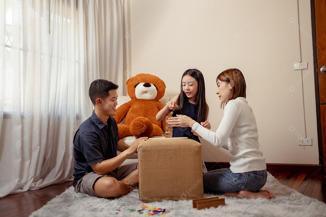 Feliz família asiática se divertindo jogando jogo de blocos em casa