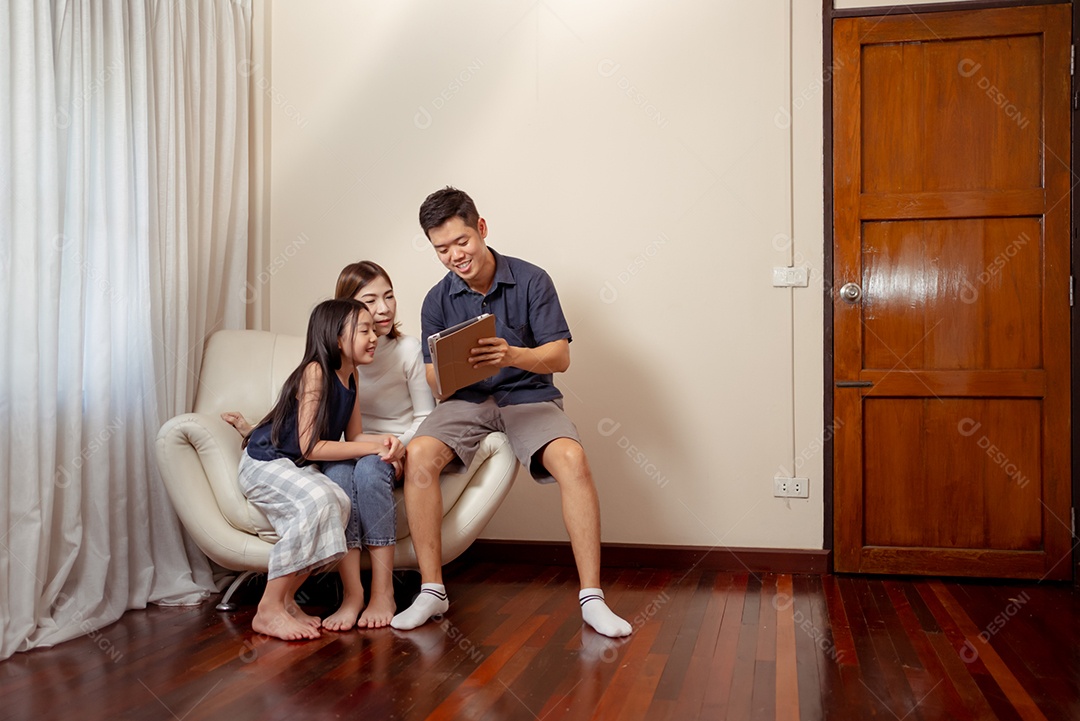 Feliz família asiática se divertindo com o dispositivo em casa