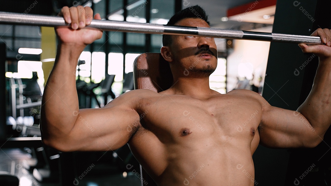 Homem fazendo exercícios na academia, levantando barra