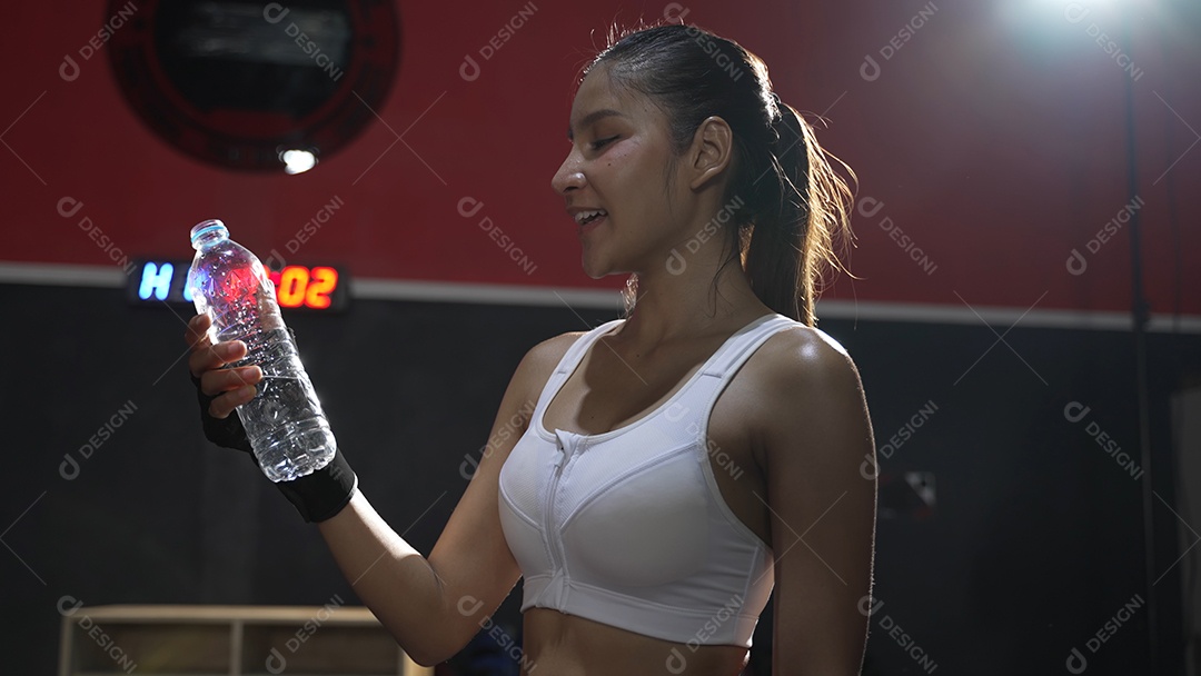 Atleta mulher asiática bebendo água pura após exercícios de treino ou treinamento