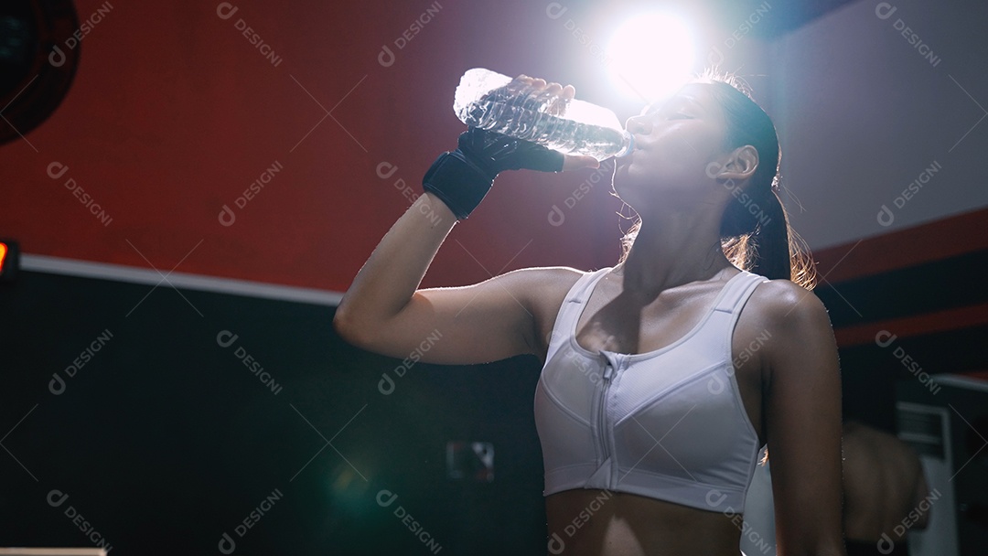 Atleta mulher asiática bebendo água pura após exercícios de treino ou treinamento