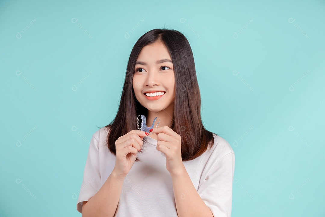 Sorriso bonito dental da jovem mulher asiática com aparelho retentor