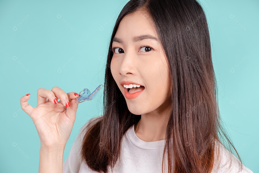 Sorriso bonito dental da jovem mulher asiática com aparelho retentor