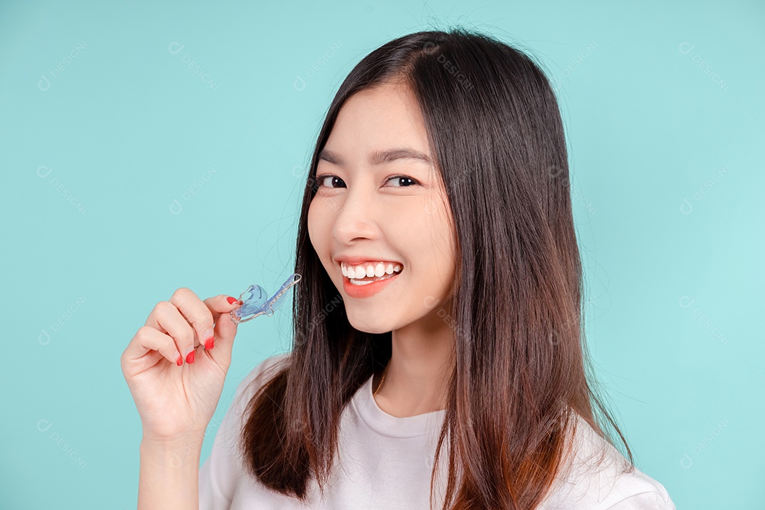 Sorriso bonito dental da jovem mulher asiática com aparelho retentor