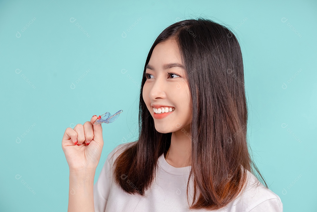 Sorriso bonito dental da jovem mulher asiática com aparelho retentor